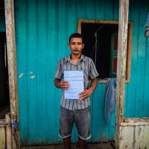 A man shows his tenure documentation, in the Amazon Forest project, Para, Brazil.