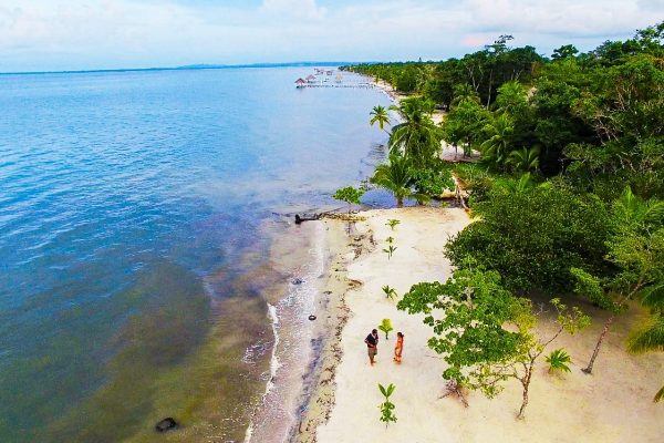 L'eau bleue et les baigneurs du projet de la côte caraïbe du Guatemala.