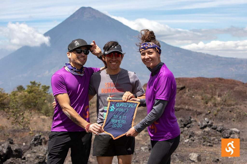 Three Impact Marathon runners in front of a volcano in Guatemala